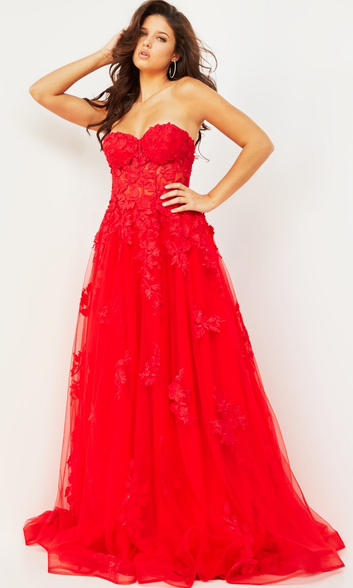 A woman in the Jovani Strapless Long Lace A-Line Prom Dress 07901 with floral lace and a sheer bodice stands against a plain background.